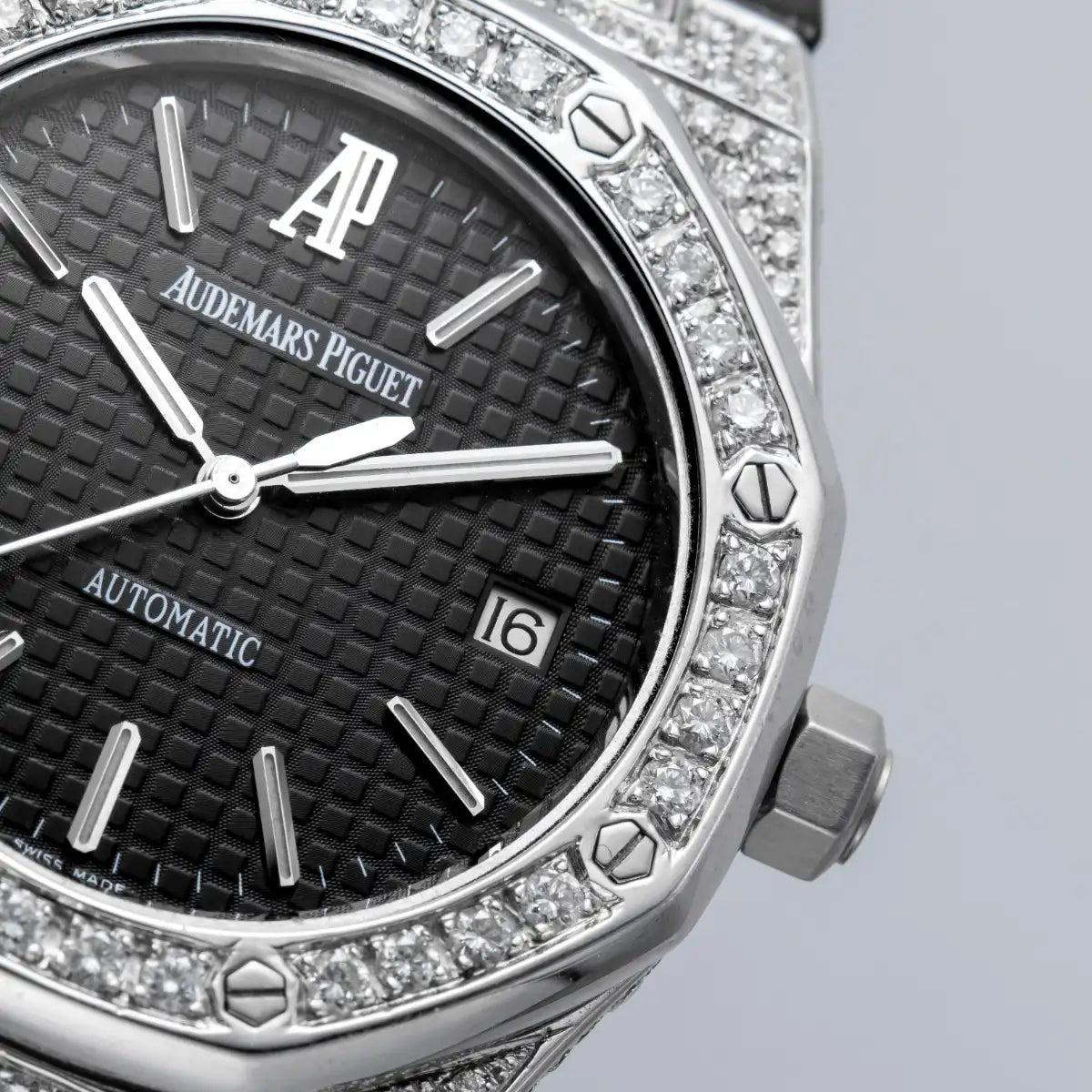 Macro shot of the dial of the Custom diamond-set Audemars Piguet Royal Oak 15300 with black dial, diamond bezel, and black leather strap.
