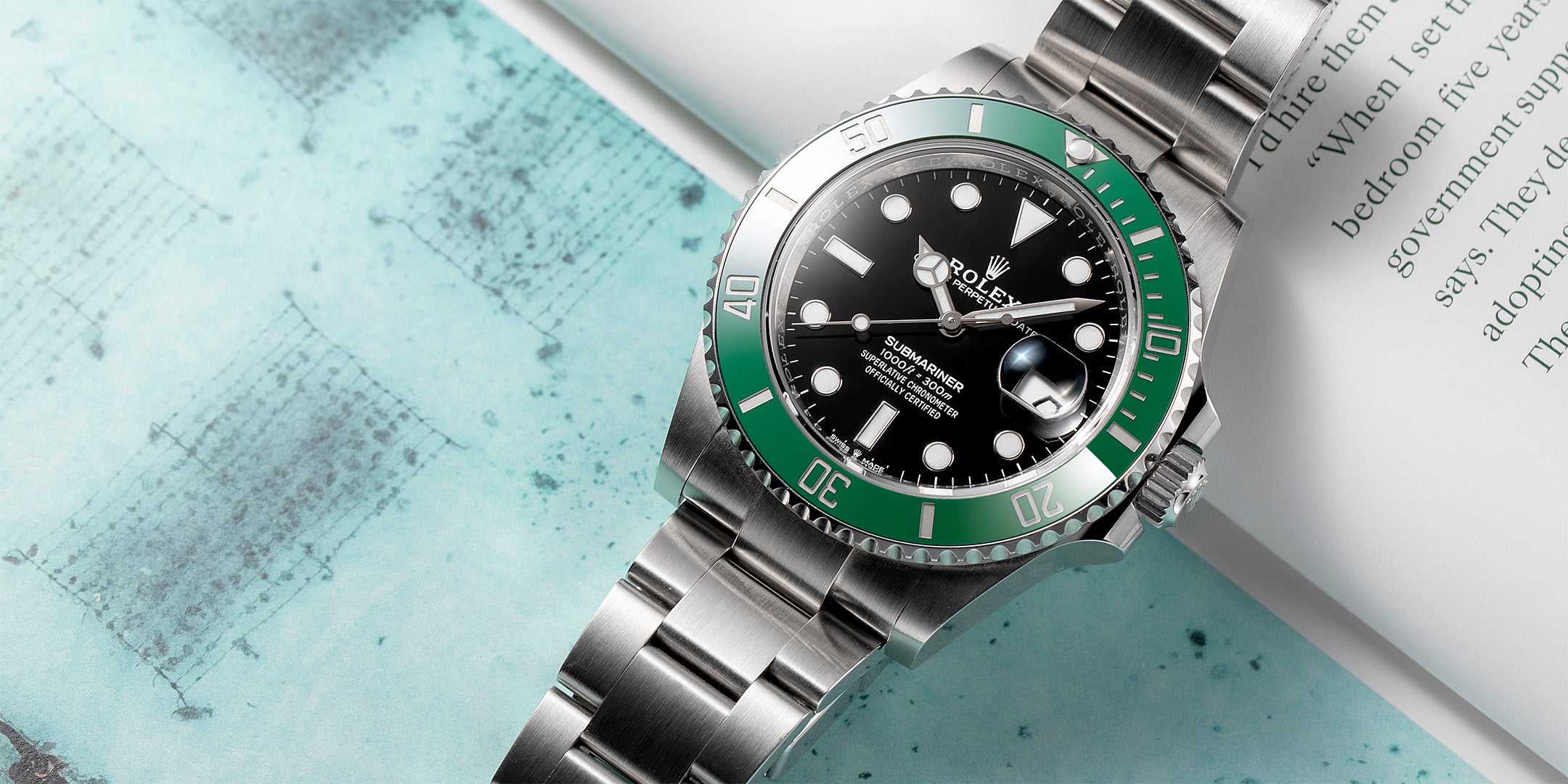 Rolex Submariner Wristwatch with green bezel and steel case on a textured surface