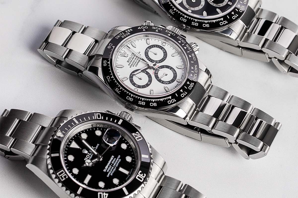 rolex daytona white dial and rolex submariner black dial ceramic on a white surface